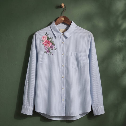 Women's light blue striped button-up shirt with pink floral embroidery – front view on hanger