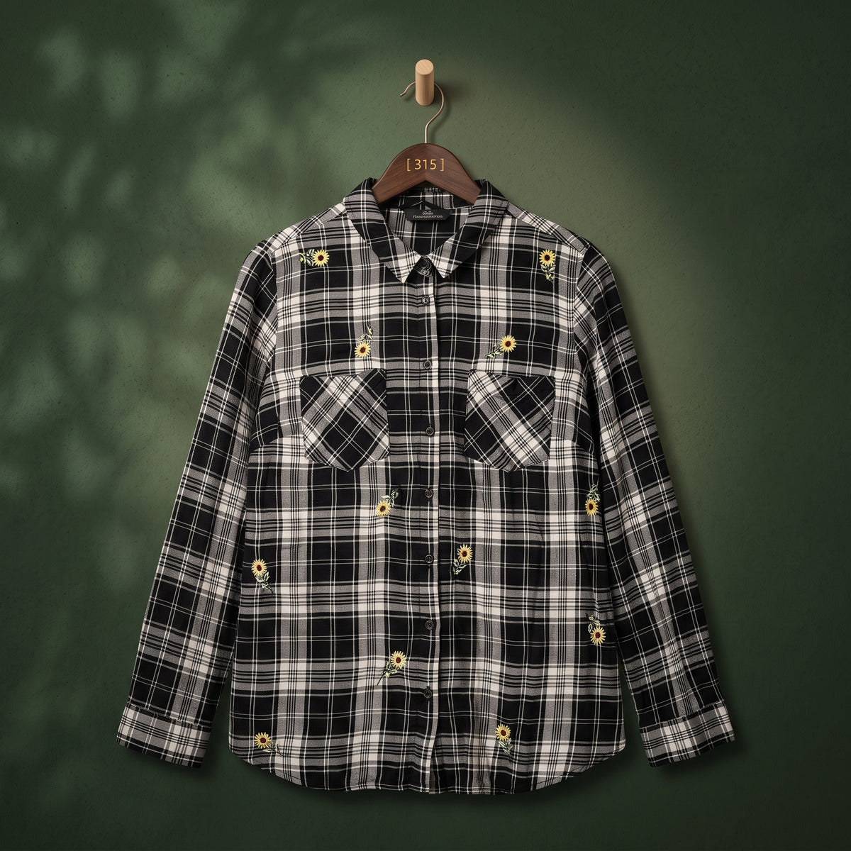 Women's black and white plaid shirt with sunflower embroidery and two chest pockets – front view on hanger