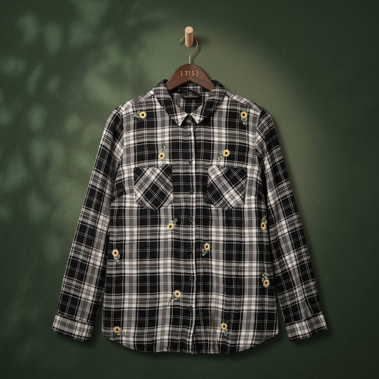 Women's black and white plaid shirt with sunflower embroidery and two chest pockets – front view on hanger